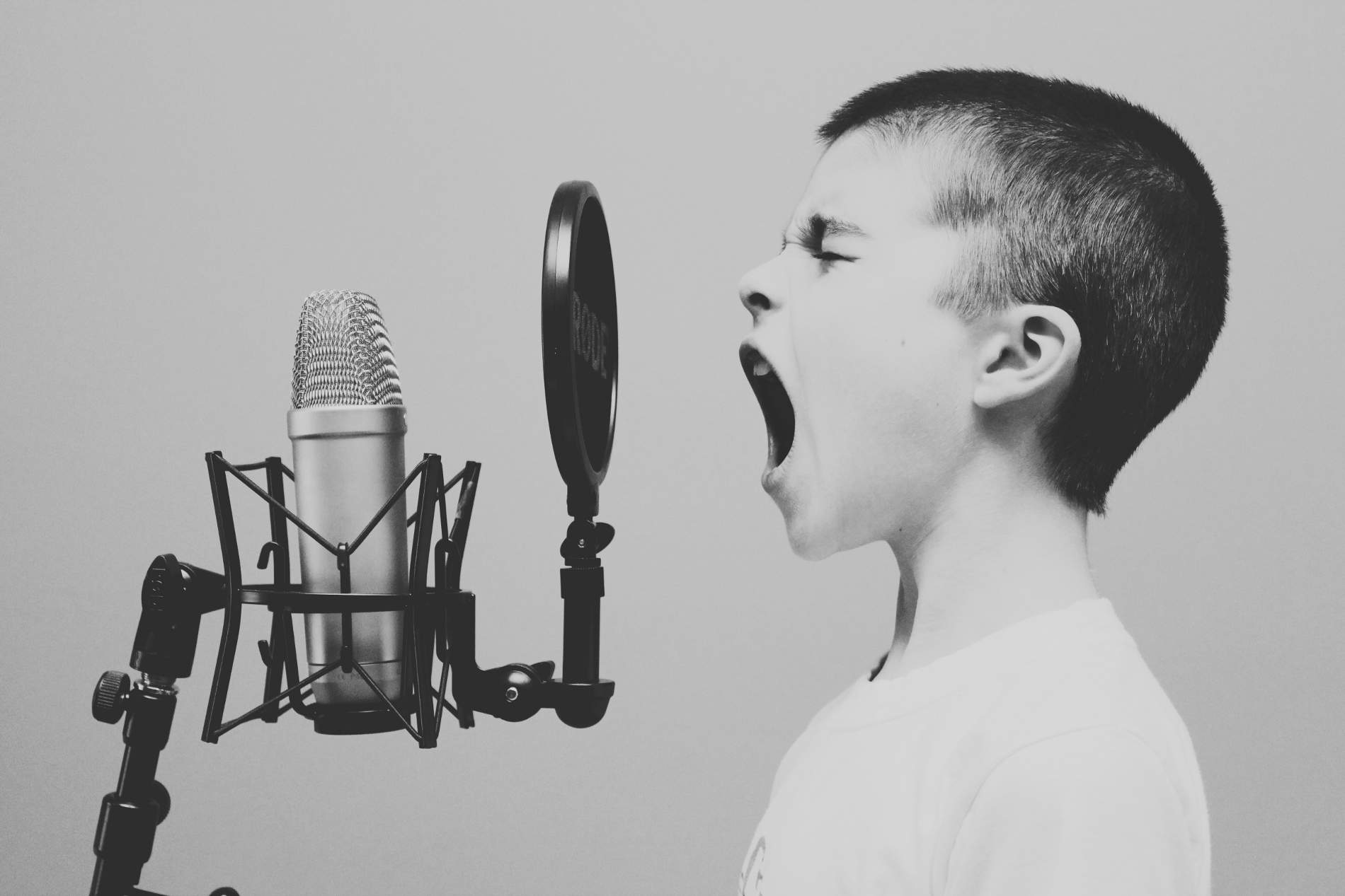 young boy singing into studio microphone