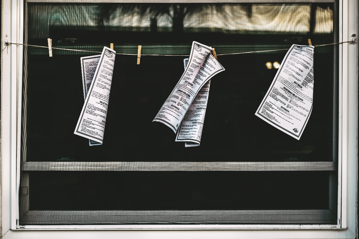 pages of a manifesto on clothespins hanging in an open window
