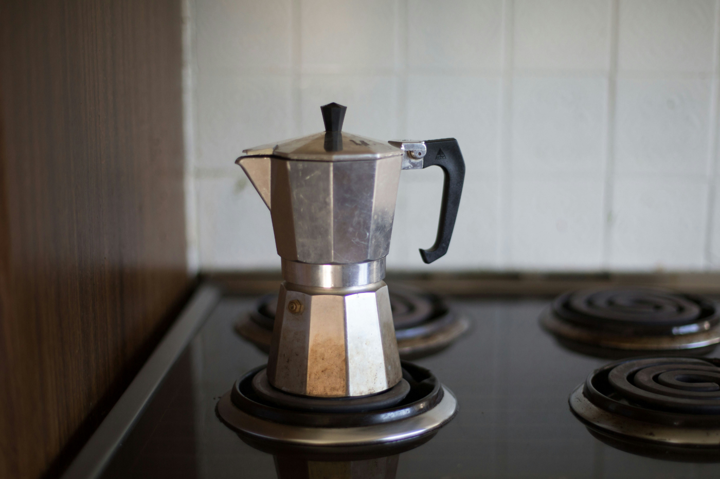 A silver coffee percolator on a stove.