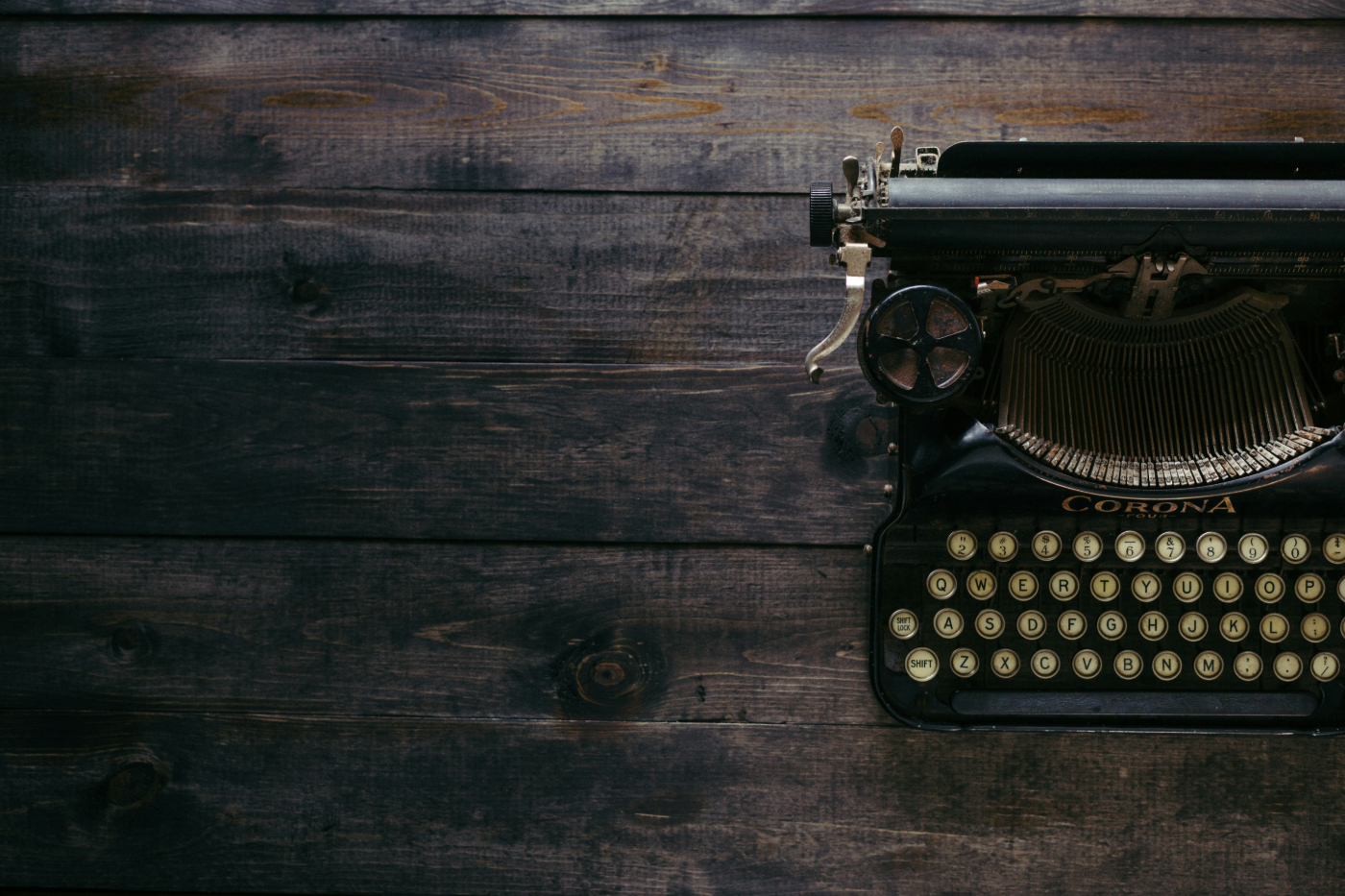 An old Smith Corona typewriter on a wood table pushed to the right side of the frame