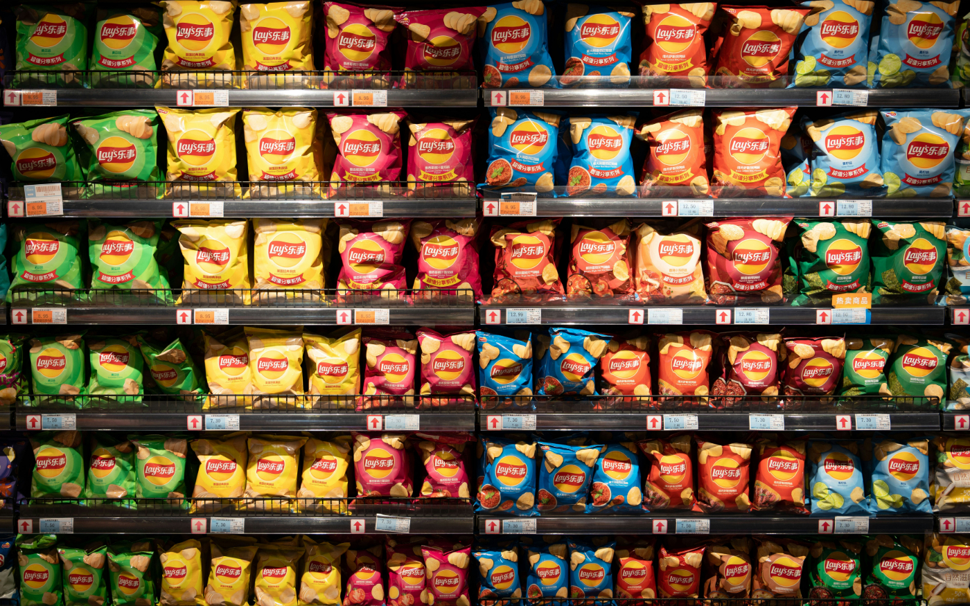 A grocery shelf with hundreds of bags of varieties of Lay's potato chips