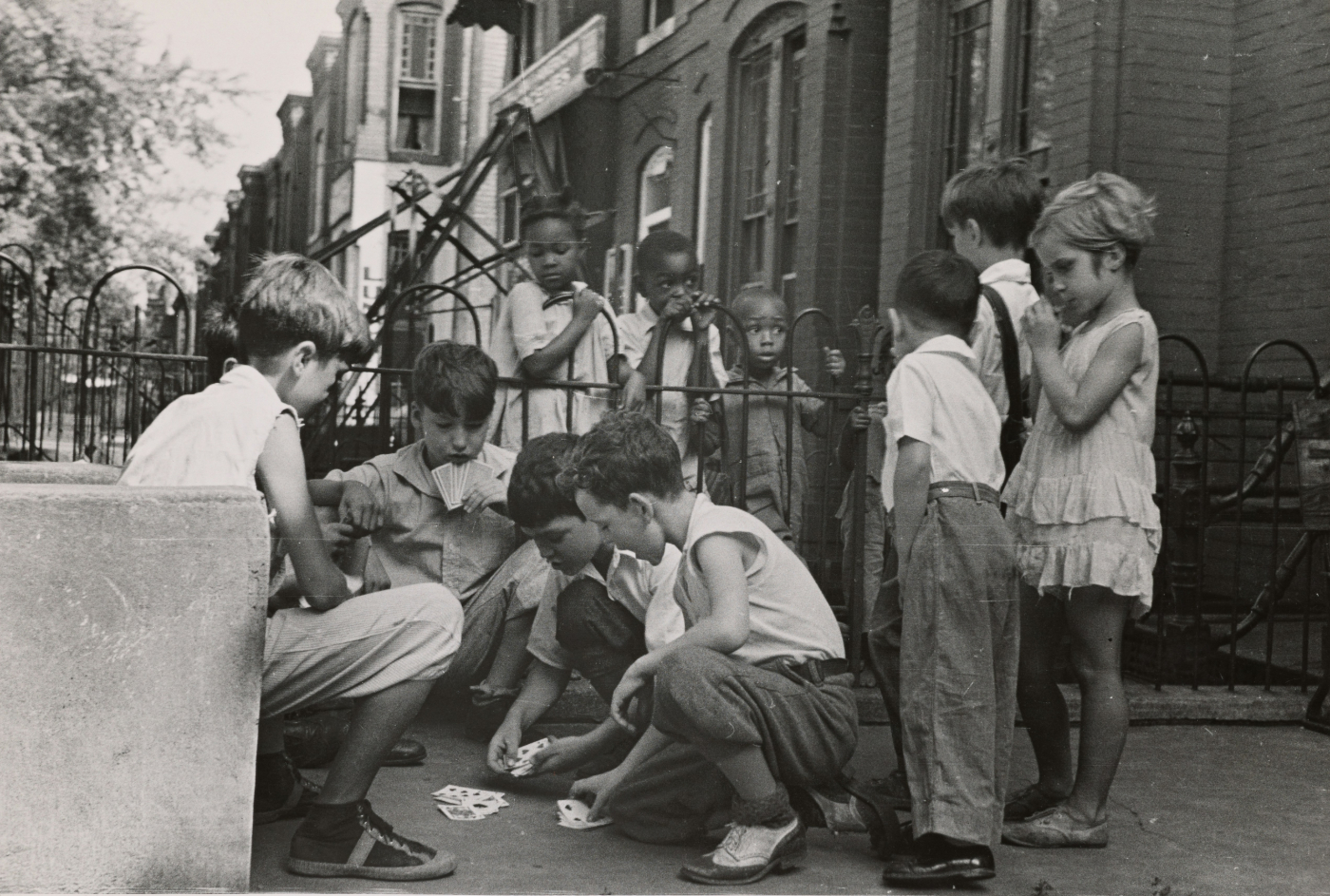A great scale image on NYC circa 1950's, kids on the street playing cards with others watching