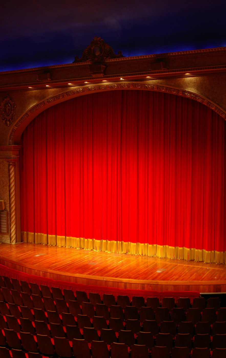 A red and yellow grand drape on an empty stage