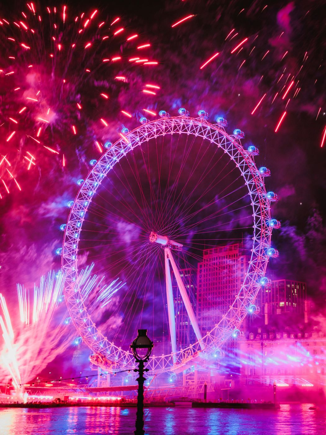 A Ferris wheel under fireworks