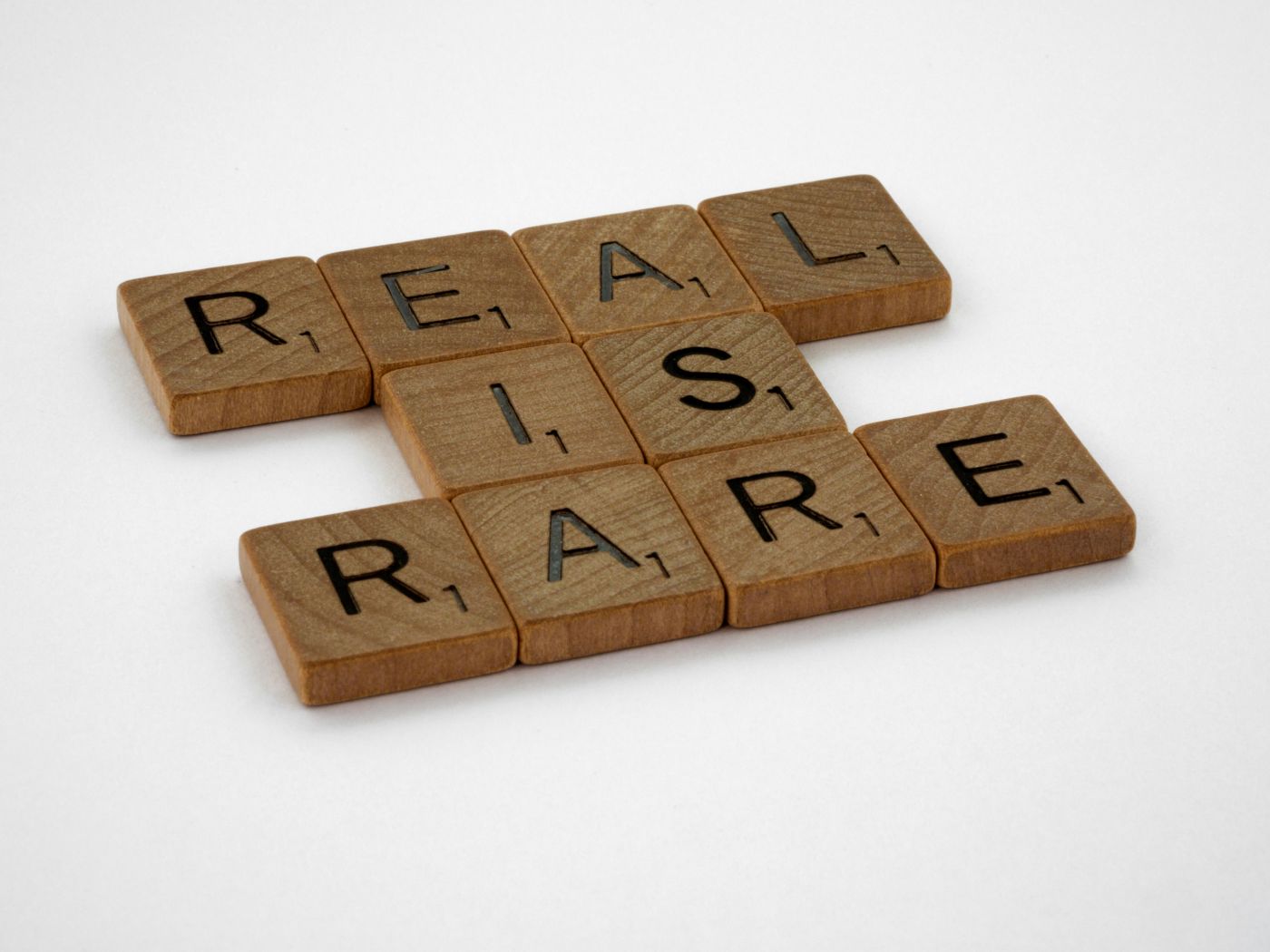 Scrabble tiles spelling out REAL IS RARE