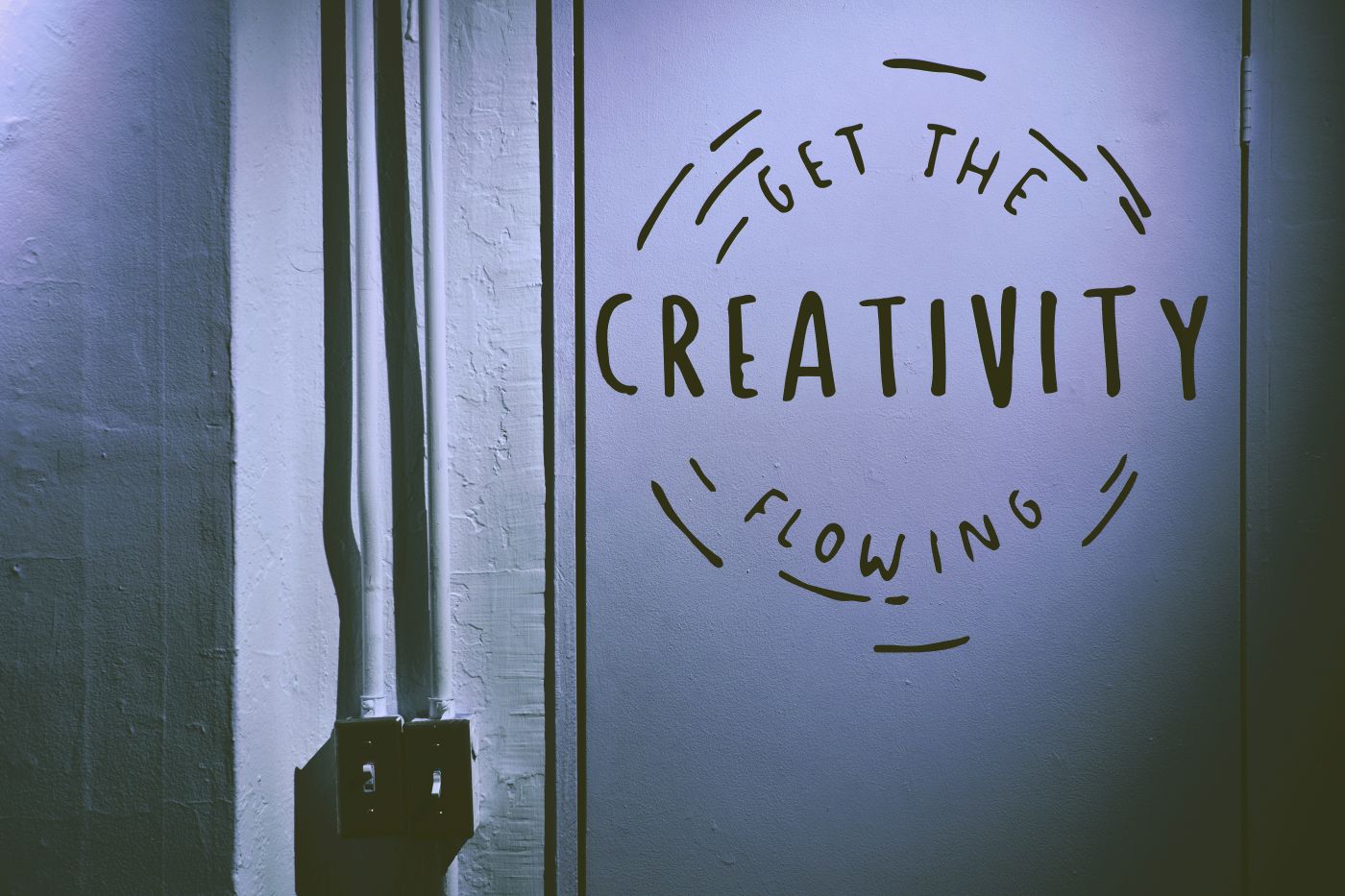 A white wall with Get The Creativity Flowing painted on it