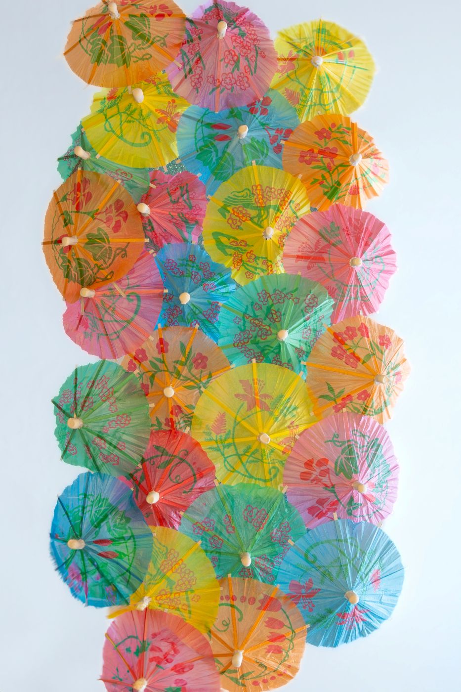 A vertical wall of colorful cocktail umbrellas