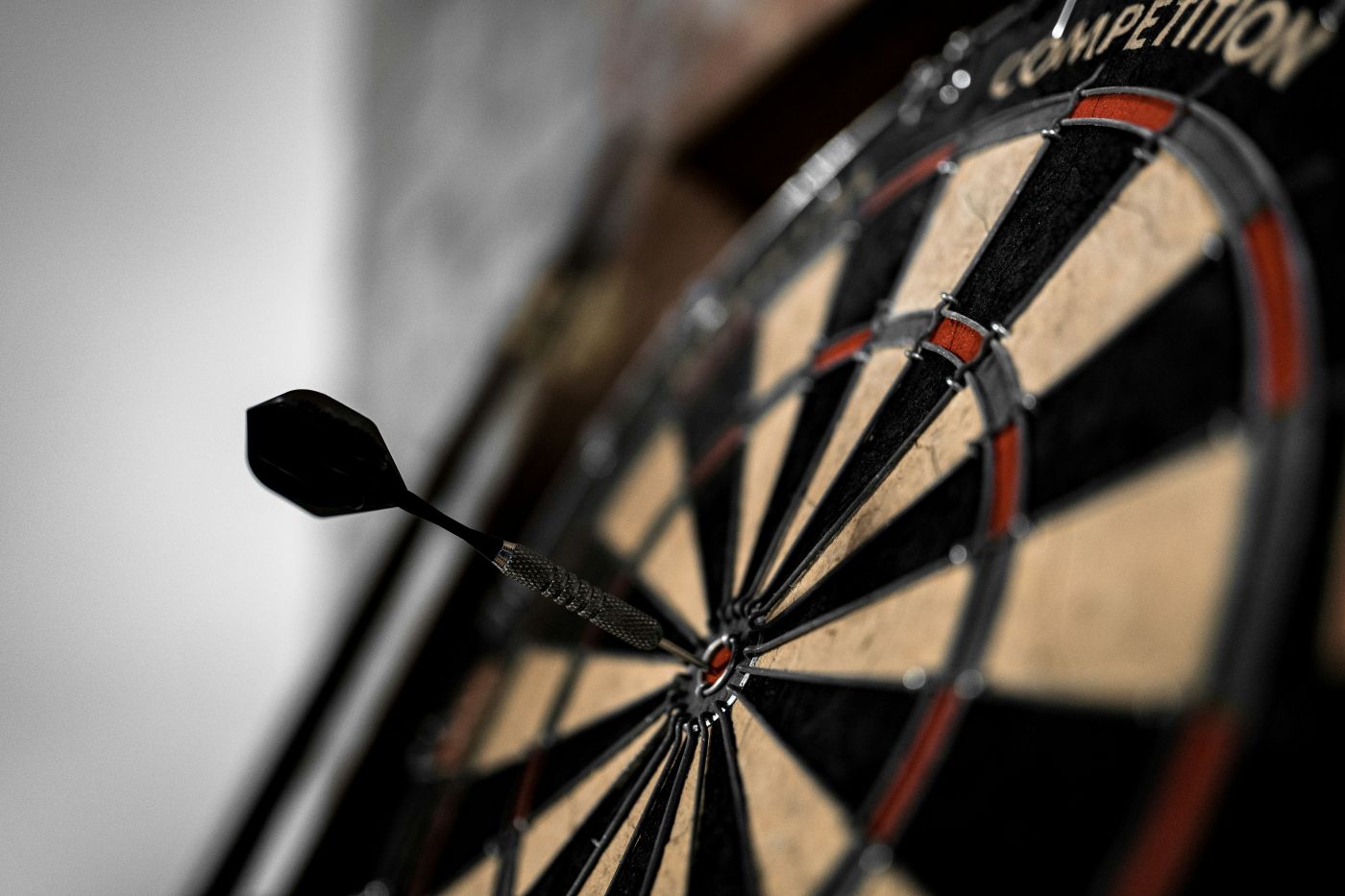 A dart board with a black dart in the bull's eye
